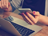 Person holding a phone an laptop